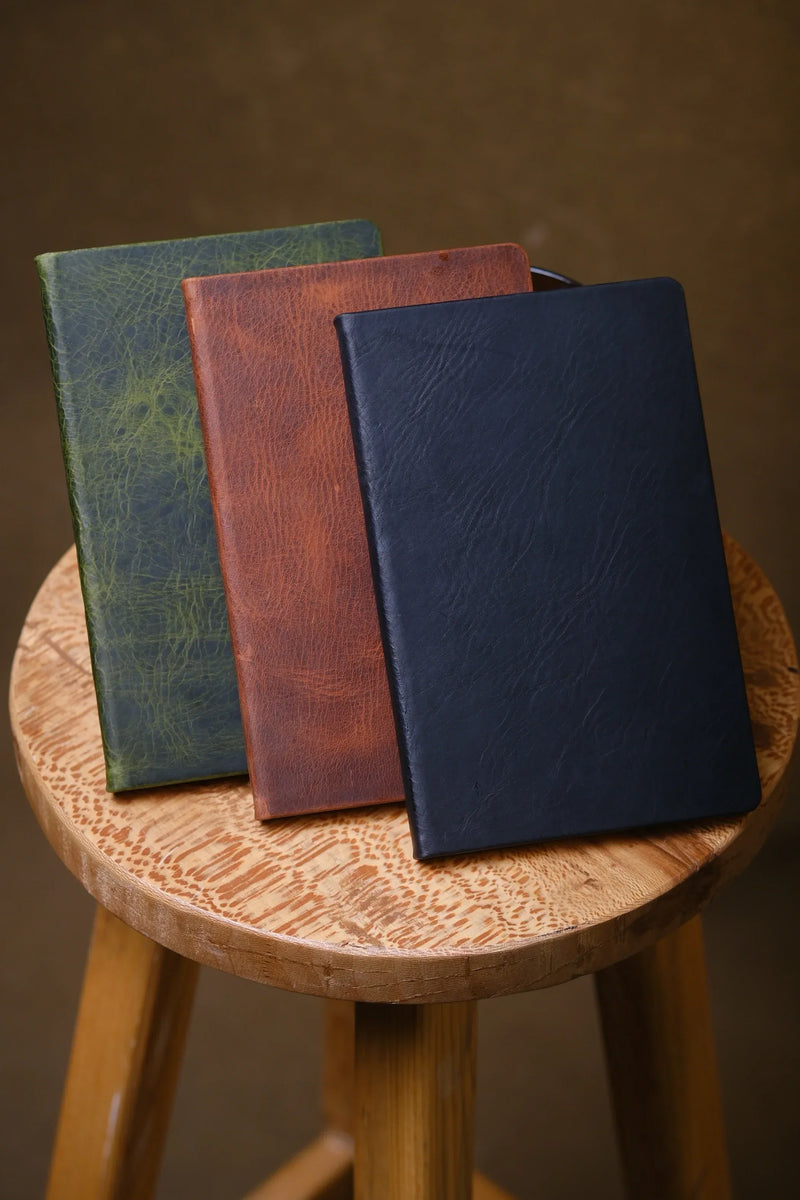 Three leather journal notebooks in green, tan and navy