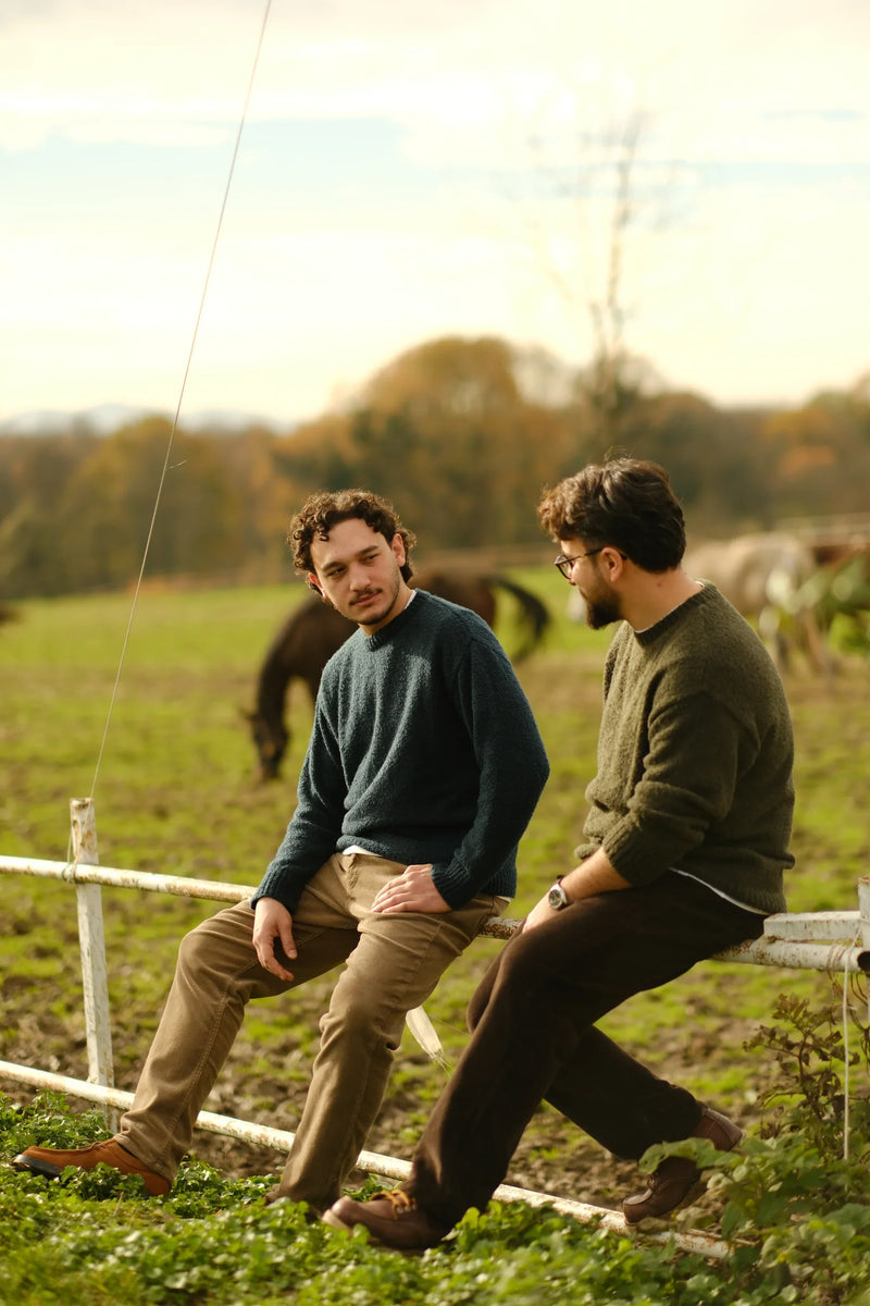 Two men wearing wool-blend knit sweaters outdoors