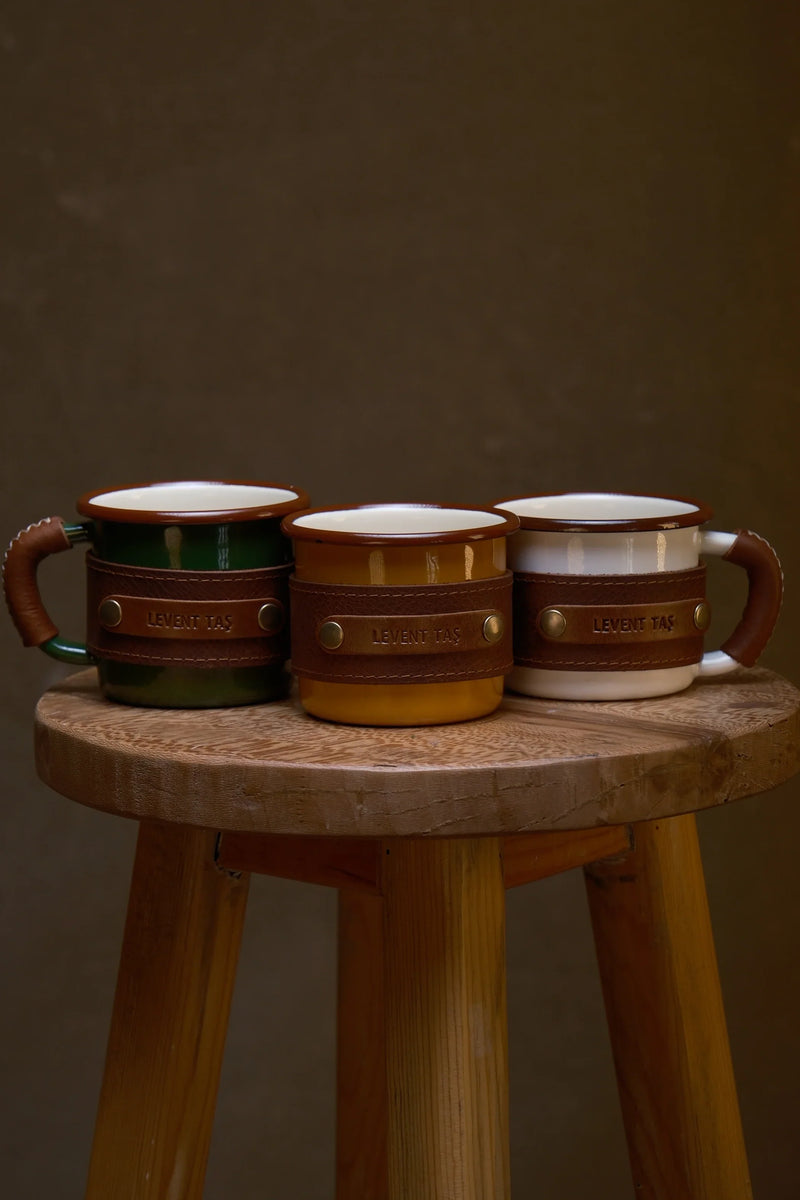 Three enamel mugs wrapped in full grain leather
