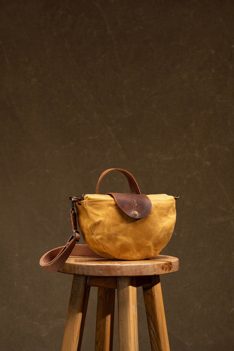 Mustard canvas half-moon women's bag with a leather flap