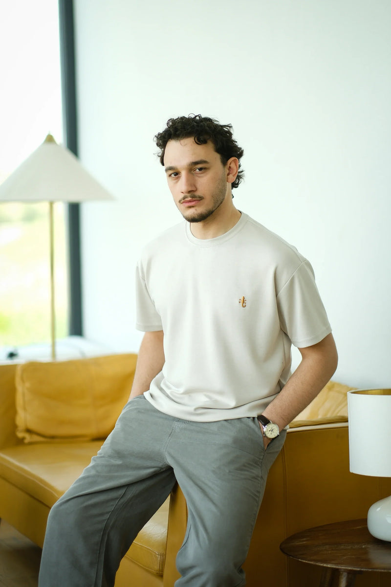 Man wearing a cream embroidered t-shirt