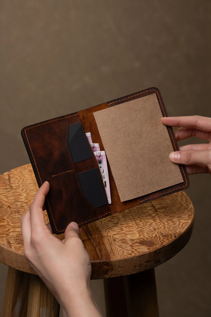 Hands holding an open leather travel wallet
