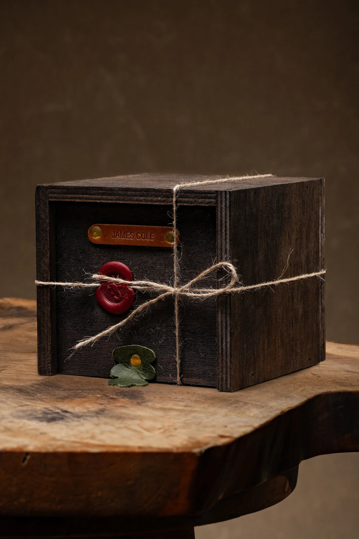 Name-stamped leather plate on the lid of a wooden gift box